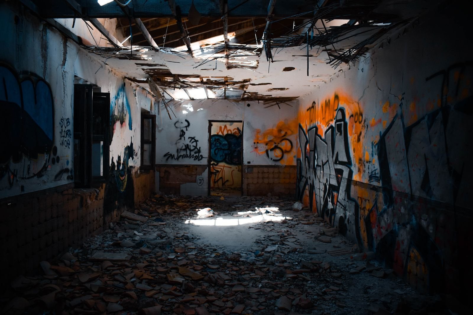 Intérieur de bâtiment vacant entièrement recouvert de tags, état constaté avant remise en état après occupation illégale
