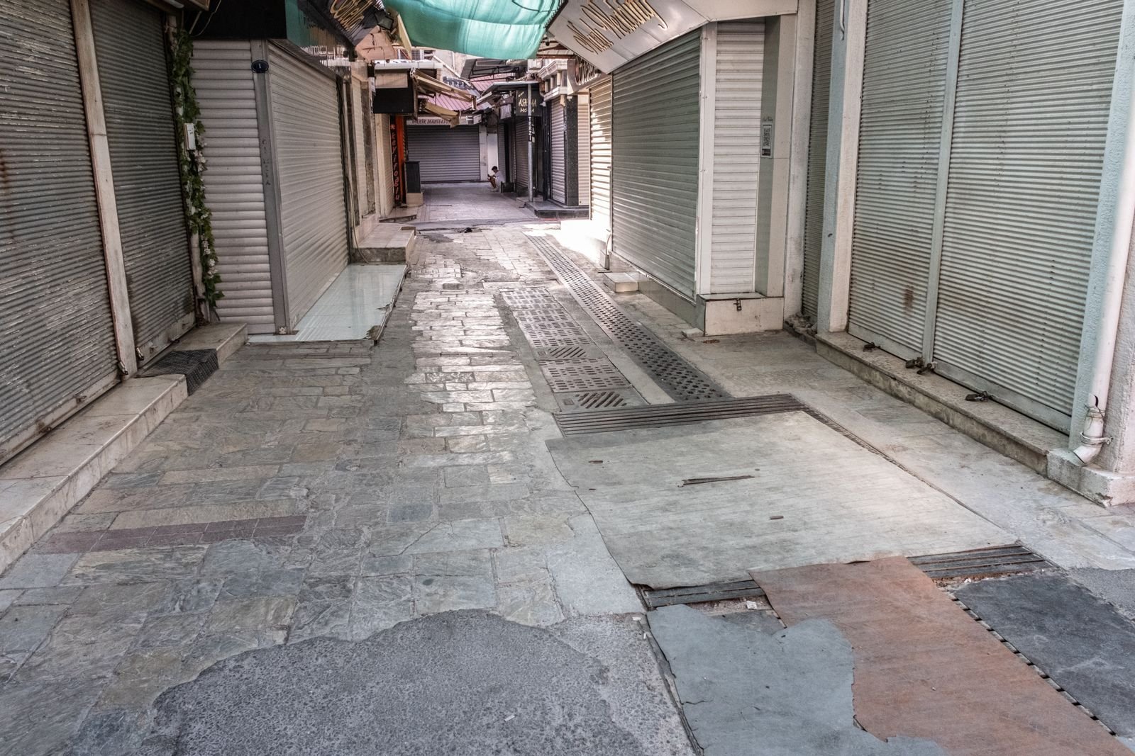 Ruelle étroite bordée de rideaux métalliques baissés, configuration courante des commerces fermés du centre ancien de Toulon
