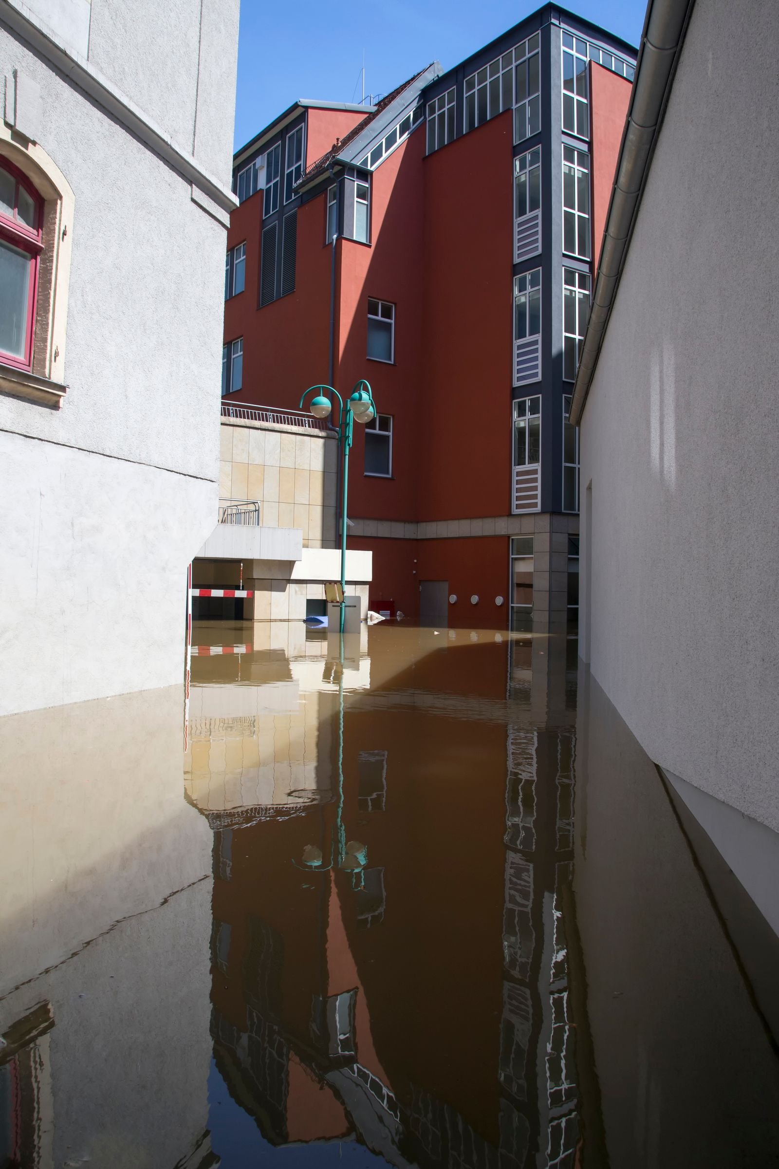 Rue de ville submergée par les eaux de ruissellement après un orage violent, avec bâtiments les pieds dans l'eau